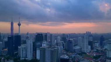 Kuala Lumpur şehri, kentsel gelişimi temsil eden aydınlık Merdeka 118 gökdeleni ve KL Kulesi 'nin yer aldığı güzel bir günbatımında ufuk çizgisine sahiptir. Yukarıdan drone atışı