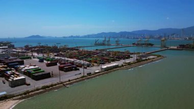 Penang Limanı 'nın Kuzey Butterworth Terminali' nin kıyı şeridi boyunca sayısız nakliye konteynırı, vinç ve gemileriyle hava görüntüsü. panorama genel görünüm dronu