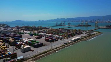 Penang Limanı 'nın Kuzey Butterworth Terminali' nin kıyı şeridi boyunca sayısız nakliye konteynırı, vinç ve gemileriyle hava görüntüsü. İHA yükseltiliyor