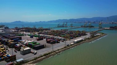 Penang Limanı 'nın Kuzey Butterworth Terminali' nin kıyı şeridi boyunca sayısız nakliye konteynırı, vinç ve gemileriyle hava görüntüsü. Yukarıdan drone atışı