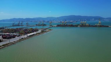 Küresel ticaret ve lojistik sektörünü temsil eden nakliye konteynırları ve vinçlerle dolu bir konteyner limanı. rotasyon tavası sol drona
