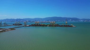 Küresel ticaret ve lojistik sektörünü temsil eden nakliye konteynırları ve vinçlerle dolu bir konteyner limanı. Yukarıdan drone atışı