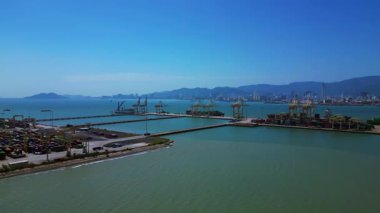 Küresel ticaret ve lojistik sektörünü temsil eden nakliye konteynırları ve vinçlerle dolu bir konteyner limanı. panorama genel görünüm dronu