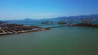 Küresel ticaret ve lojistik sektörünü temsil eden nakliye konteynırları ve vinçlerle dolu bir konteyner limanı. rotasyon pan 'dan sağ drona