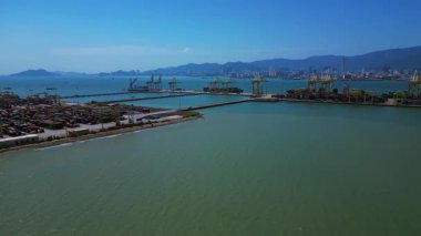 Küresel ticaret ve lojistik sektörünü temsil eden nakliye konteynırları ve vinçlerle dolu bir konteyner limanı. Yukarıdan drone atışı