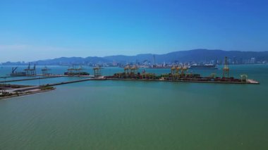 Küresel ticaret ve lojistik sektörünü temsil eden nakliye konteynırları ve vinçlerle dolu bir konteyner limanı. rotasyon tavası sol drona