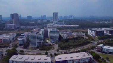 Gelişmekte olan bir teknoloji parkındaki modern binaları, yeşil alanları, yolları ve güneş panellerini gösteren hava manzarası. Yukarıdan insansız hava aracı mermisi