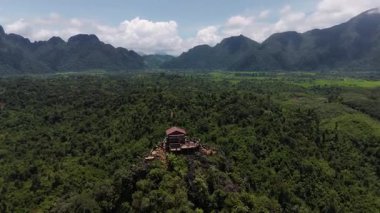İnsansız hava aracı atışları Vietnam 'dan uçarak uzaklaşıyor ve Vang Vieng' in çarpıcı karst manzarasını gözler önüne seriyor.