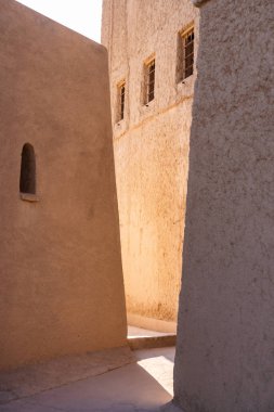 Umman sokağındaki geleneksel çamur tuğlalarını aydınlatan güneş ışığı desenli duvarları aydınlatıyor.