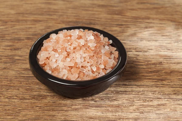 Salt; pink himalayan salt crystals, photo on wooden background.