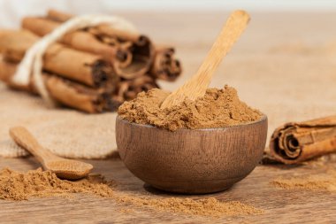 Tarçın tozu ve tarçın çubuğu; tahta arka planda fotoğraf.