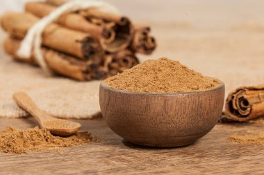 Tarçın tozu ve tarçın çubuğu; tahta arka planda fotoğraf.