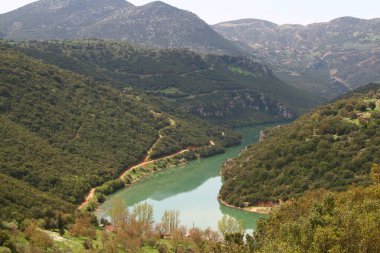Yunanistan 'ın Arcadia kentindeki Ladonas Nehri ve yapay gölünün manzarası, karla kaplı manzaralar ve huzurlu bir kış ortamı arasında yer alıyor.