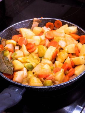 Top view of chopped fresh vegetables frying on a pan. Close up view of delicious and healthy vegetables seasoned.