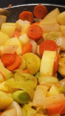 Top view of chopped fresh vegetables frying on a pan. Close up view of delicious and healthy vegetables seasoned.