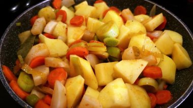 Top view of chopped fresh vegetables frying on a pan. Close up view of delicious and healthy vegetables seasoned.