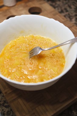 Bir kadının çatalla yumurta çırptığı yüksek bir manzara. Evde yemek tarifi. Ev yapımı yemek..