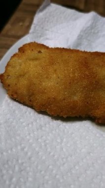 Yumuşak ve çıtır çıtır kızarmış tavuk filetoları emici kağıdın üzerinde duruyor..