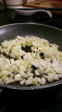 Sıcak tavada zeytinyağıyla kızartılmış doğranmış soğan yakın çekim. Sağlıklı aşçılık kavramı.