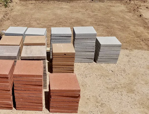 Stacks of Four Different Colored Pavers on Ground, Building a Backyard Patio. High quality photo