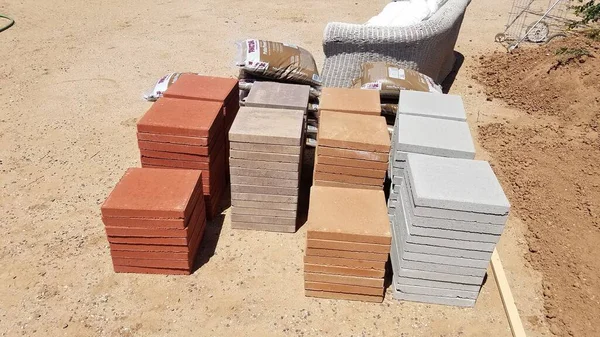 Stacks of Four Different Colored Pavers on Ground, Building a Backyard Patio. High quality photo