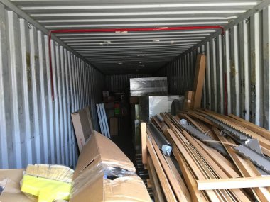 Karton kutular ve sahte plastik tahta çıtçıtlarla dolu bir konteynır. Yüksek kalite fotoğraf