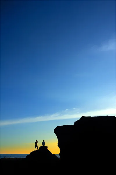 A silhouette of young couple taking photograph — Stock Photo, Image