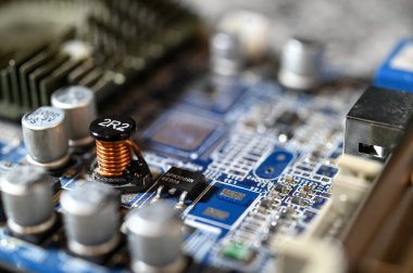 Mavi baskılı devre üzerinde konnektörleri, dirençleri ve bileşenleri olan elektronik devre kartının yakın görüntüsü.