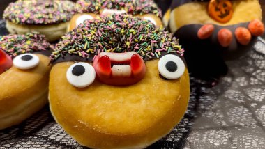 Komik cadılar bayramı çöreği şekerli gözlerle, dişlerle, şekerlerle ve çikolatalı kremalarla süslenmiş..