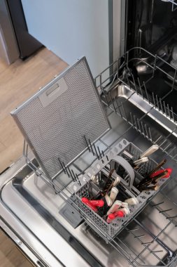 Kolay temizlik için bulaşık makinesine konan kaput yağı filtresi modern bir evde mutfak malzemelerinin bakımını gösteriyor. Yüksek açı görünümü.