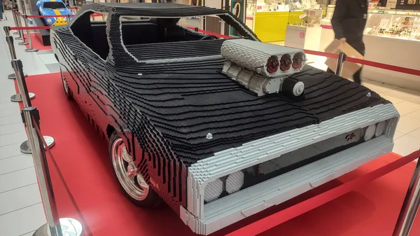 Saint Amand les Eaux, Fransa - 10 18 2025: Detaylı motor ve şık tasarımlı gerçek boyutlu LEGO araba modeli alışveriş merkezleri sergisinde kırmızı halıda sergilendi.