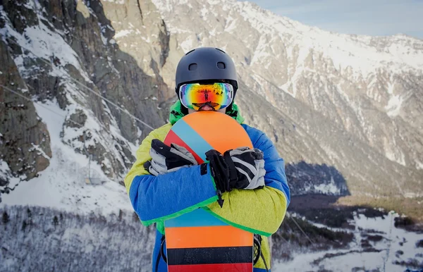 Snowboardåkare hålla snowboard på toppen av kullen i närheten upp porträtt, snö berg snowboard på sluttningar — Stockfoto