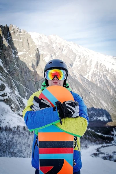 Snowboard üstüne yakın tepeye portre, kar dağların yamaçlarında snowboard snowboard tutun