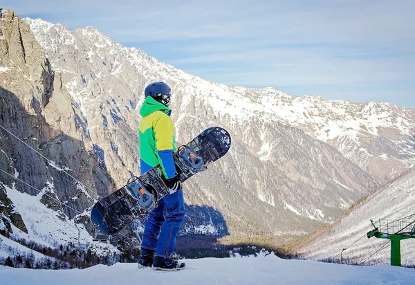 Snowboard üstüne yakın tepeye portre, kar dağların yamaçlarında snowboard snowboard tutun