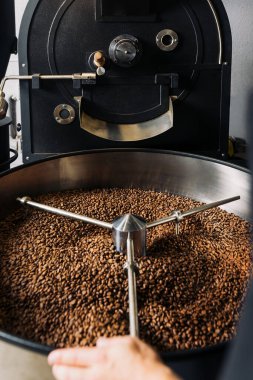 Kavrulmuş kahve makinesi ve bir varil dolusu fasulye.