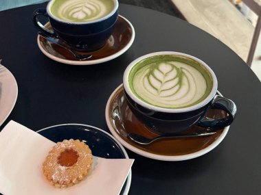 Kafedeki masada bir fincan matcha latte.