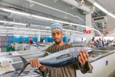 Middle East, Arabian Peninsula, Oman, Muscat, Muttrah. Oct. 21, 2019. Vendor selling tuna at the fish souk in Muttrah. clipart