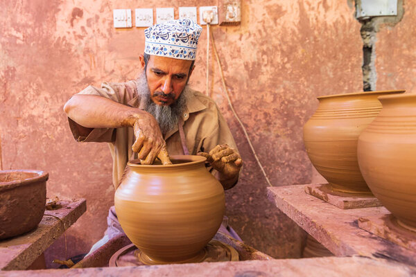 Middle East, Arabian Peninsula, Oman, Ad Dakhiliyah, Bahla. Oct. 23, 2019. Man working at a potter's wheel at the Aladawi pottery factory in Oman.