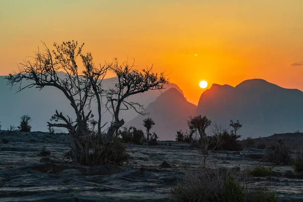 stock image Middle East, Arabian Peninsula, Oman, Ad Dakhiliyah, Al Hamra. The sun setting over mountains in the desert of Oman.