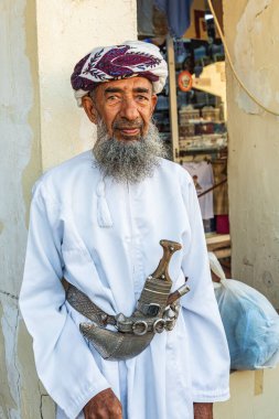 Middle East, Arabian Peninsula, Oman, Al Batinah South, Sinaw. Oct. 24, 2019. Omani man with khanjar knife at the Souk in Sinaw. clipart