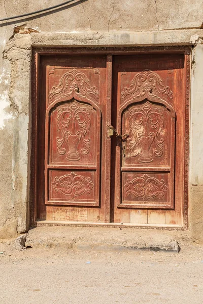 Middle East, Arabian Peninsula, Oman, Al Batinah South, Sur. Carved wooden door on a building in Oman.