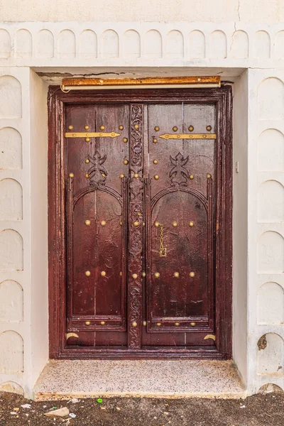 Middle East, Arabian Peninsula, Oman, Al Batinah South, Sur. Carved wooden door on a building in Oman.