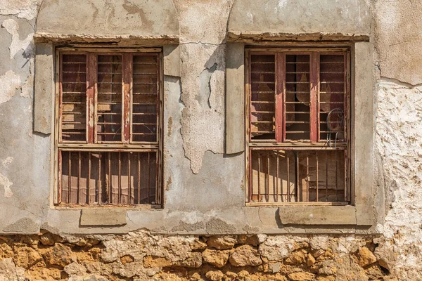 Middle East, Arabian Peninsula, Oman, Al Batinah South, Sur. Shuttered and barred windows in a crumbling wall.