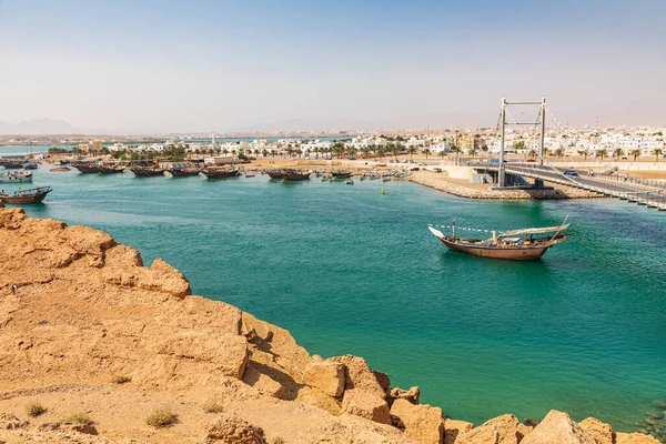 Middle East, Arabian Peninsula, Oman, Al Batinah South, Sur. Dhow passing under a suspension bridge.