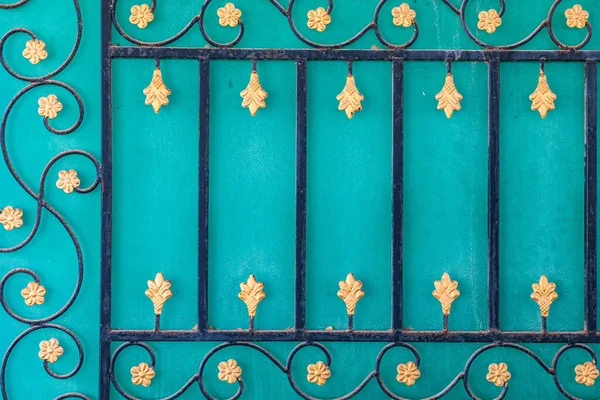 Middle East, Arabian Peninsula, Oman, Al Batinah South, Sur. Decorative metal work on a turquoise wall.