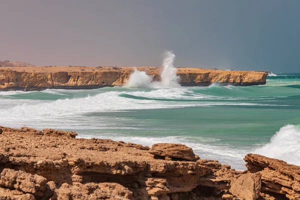 Middle East, Arabian Peninsula, Oman, Al Batinah South, Sur. Breaking surf along the rugged coast of the Arabian Sea.