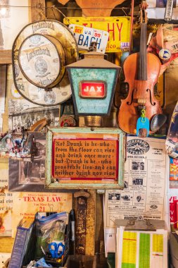 Luckenbach, Teksas, ABD. 13 Nisan 2021. Luckenbach, Teksas 'ta bir salonun duvarında bir tabela yığını..
