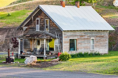 Pullman, Washington, ABD. 22 Mayıs 2021. Palouse tepelerinde yıpranmış eski bir çiftlik evi..