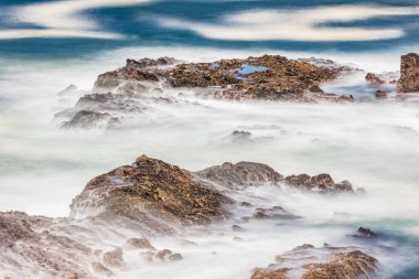 Shore Acres State Park, Oregon, ABD. Yavaş çekim hızı kayaların üzerinden akan dalgaların bulanıklığı.