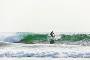Ecola State Park, Oregon, ABD. 5 Mayıs 2021. Oregon sahilinde sörf yapan bir adam.